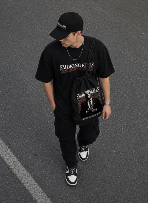 Black Oversized Graphic T-Shirt with Bold Typography Print and Back Artwork Design Paired with Matching Adjustable Cap and Printed Drawstring Bag Combo Set Streetwear Casual Outfit