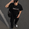 Black Oversized Graphic T-Shirt with Bold Typography Print and Back Artwork Design Paired with Matching Adjustable Cap and Printed Drawstring Bag Combo Set Streetwear Casual Outfit