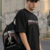 Black Oversized Graphic T-Shirt with Bold Typography Print and Back Artwork Design Paired with Matching Adjustable Cap and Printed Drawstring Bag Combo Set Streetwear Casual Outfit